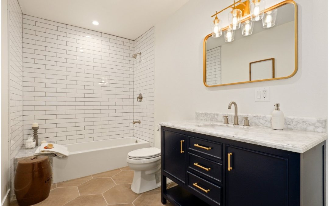 Modern bathroom renovation with white subway tile walls, a sleek bathtub, dark cabinetry, and stylish lighting in Port Charlotte, FL.