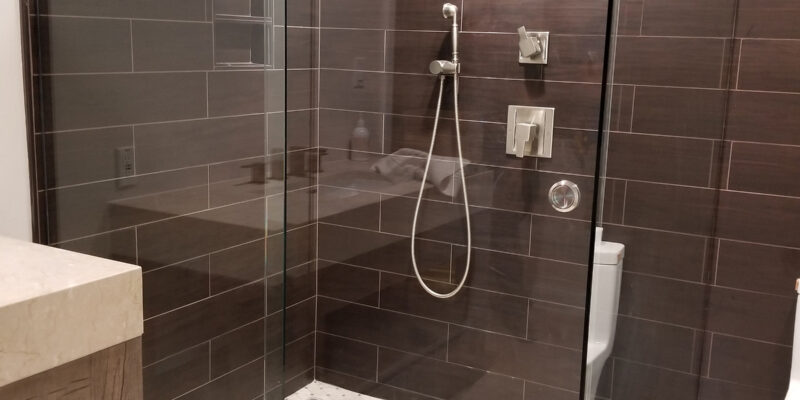 Modern bathroom renovation featuring a glass shower enclosure, sleek tile design, and contemporary fixtures in Englewood, FL.