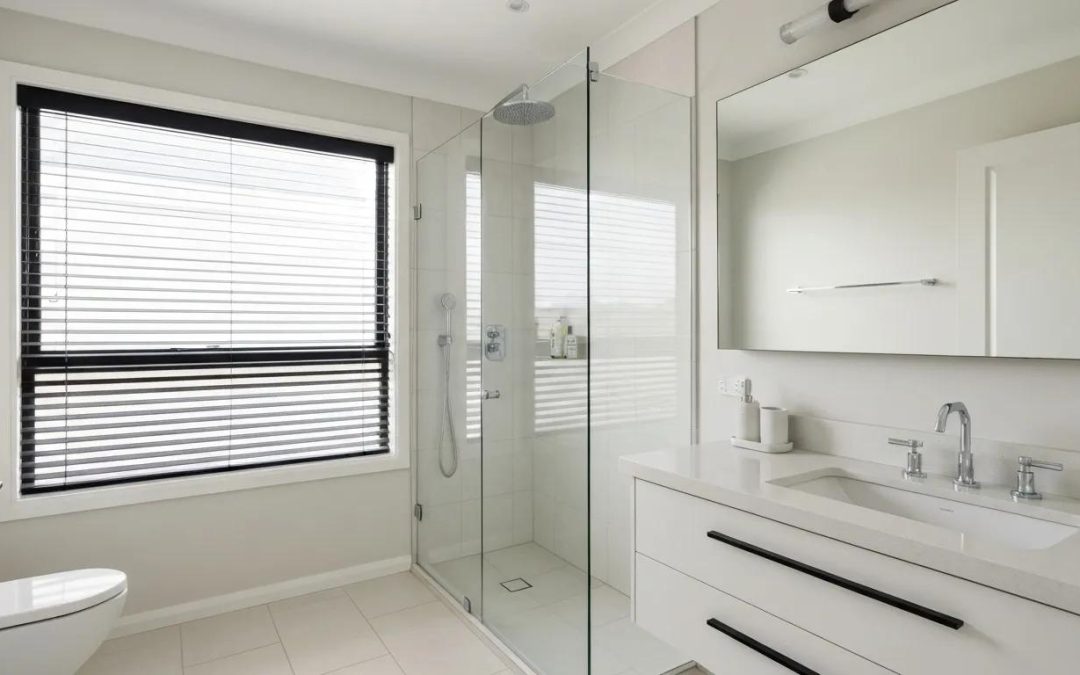 Modern bathroom design featuring a glass shower enclosure, sleek vanity with a white countertop, and a large mirror, emphasizing stylish and functional space for home renovation.